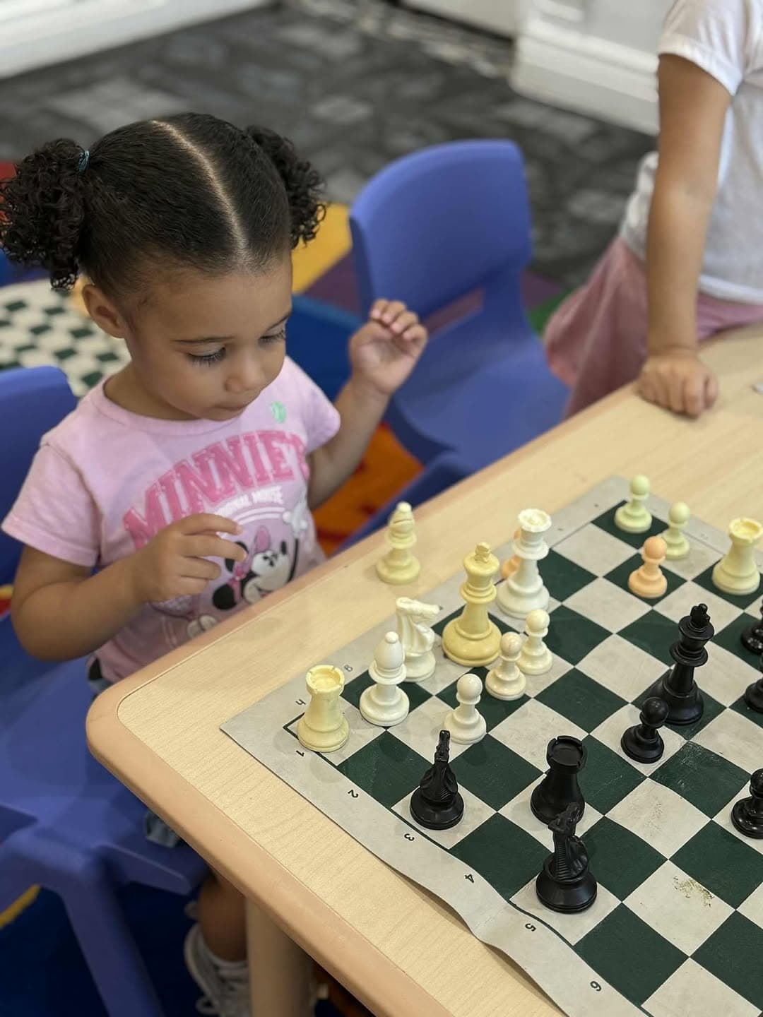 Young child studying a chess board