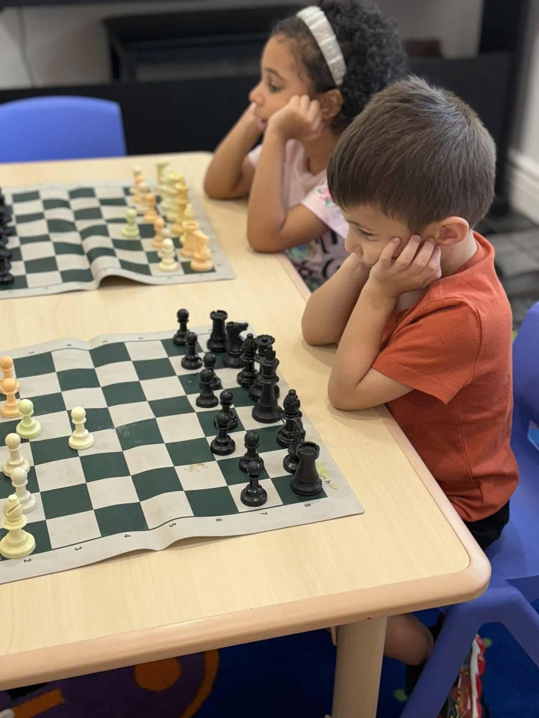 Children thinking through a chess game