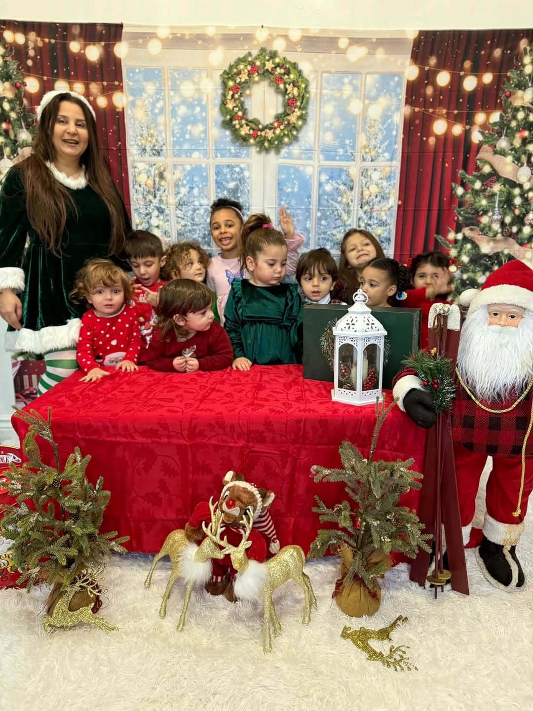 Group photo of the teacher and children at the Christmas backdrop