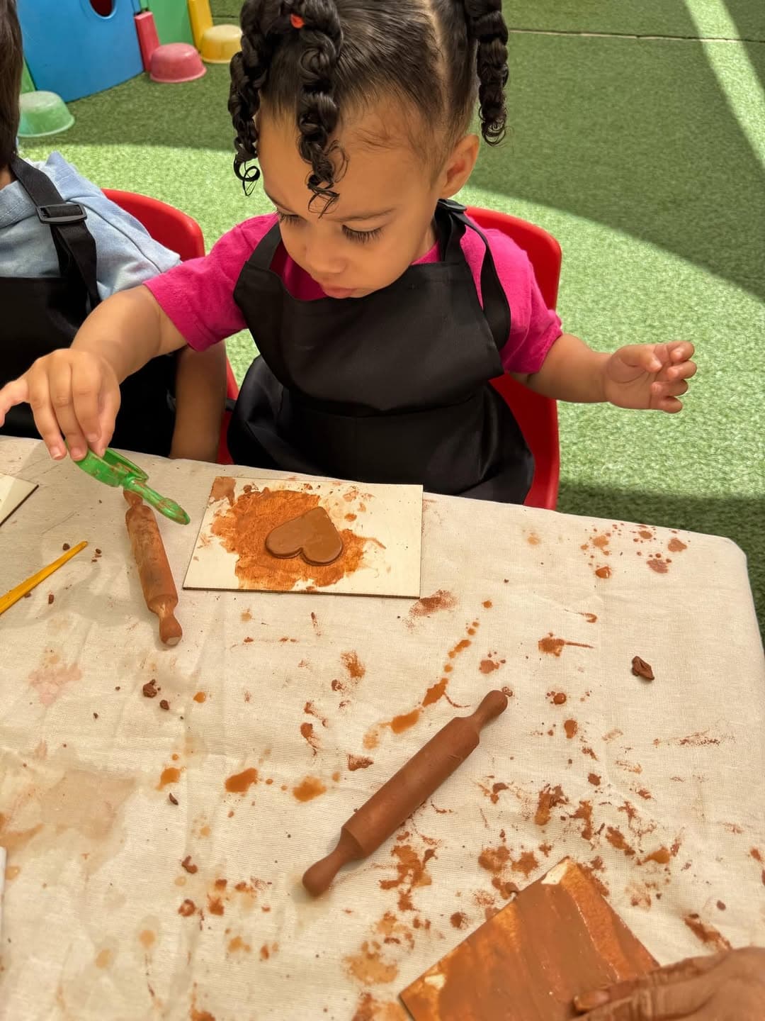 Child rolling clay during an art lesson