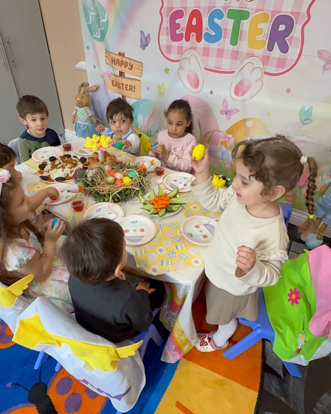 Children gathered at an Easter celebration table with decorated eggs