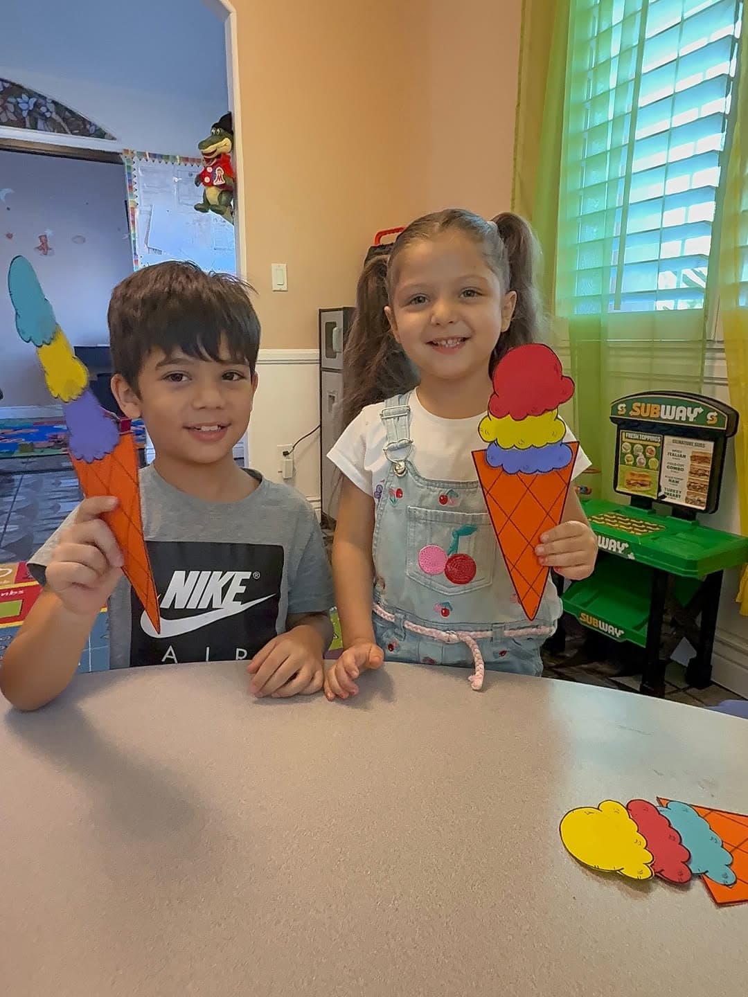 Young child holding a paper ice-cream cone craft
