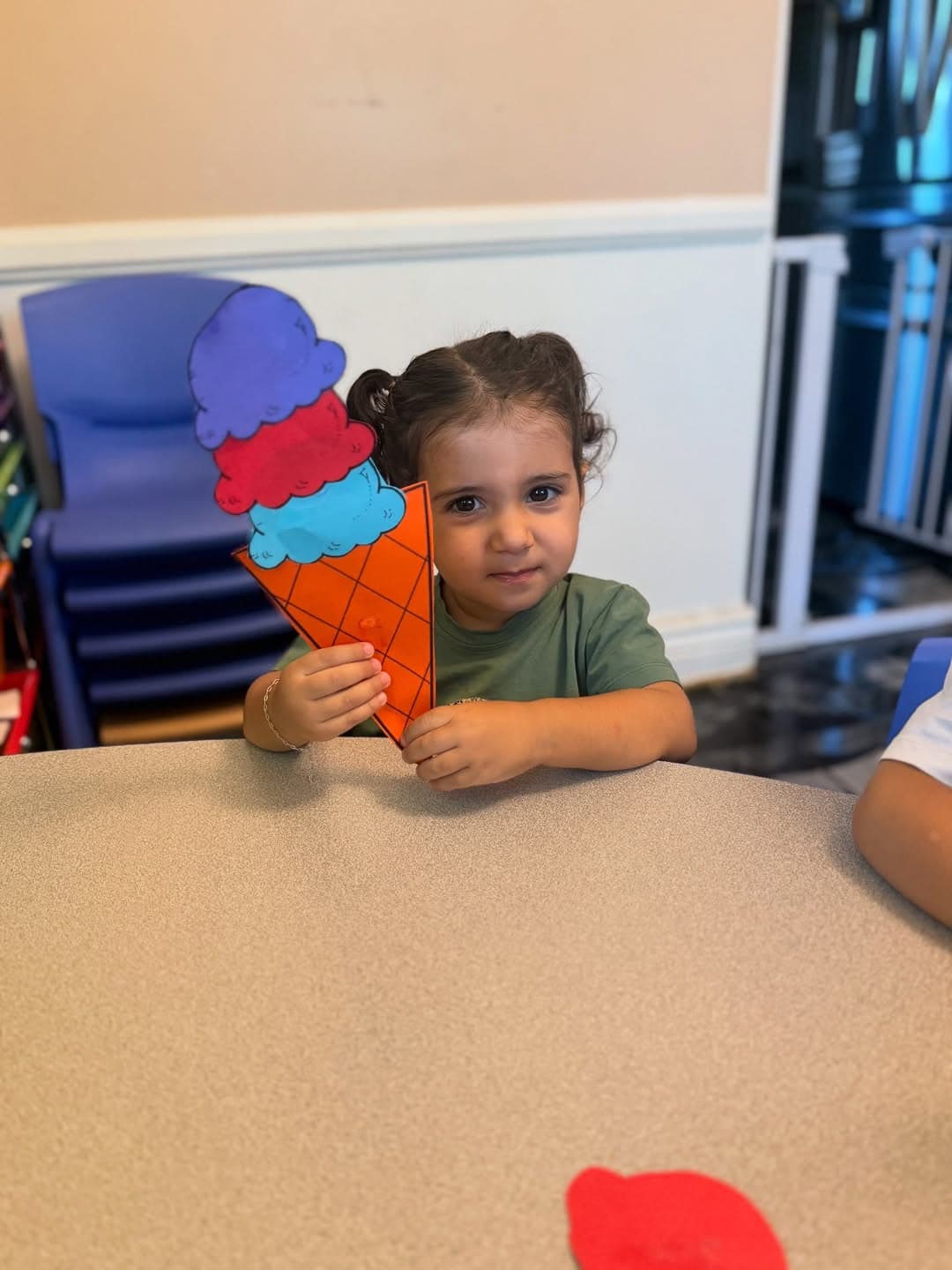 Two children smiling with paper ice-cream cone crafts