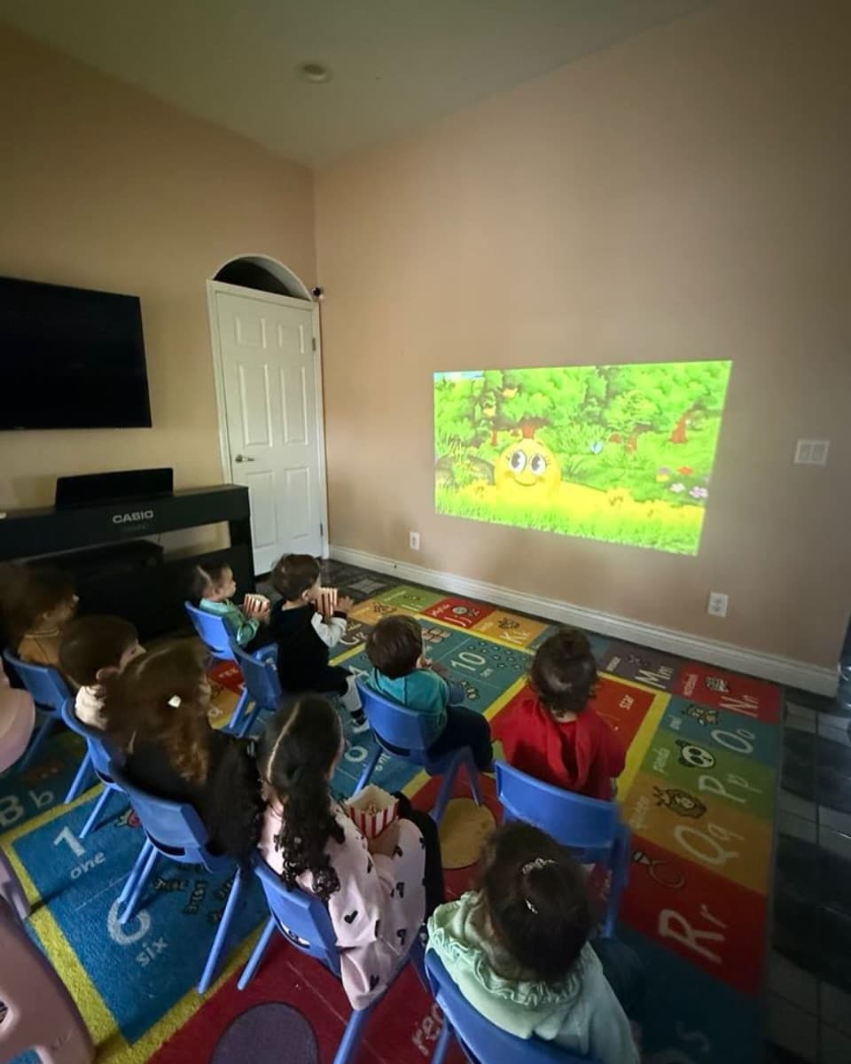 Children watching a cartoon projected on the wall during quiet time
