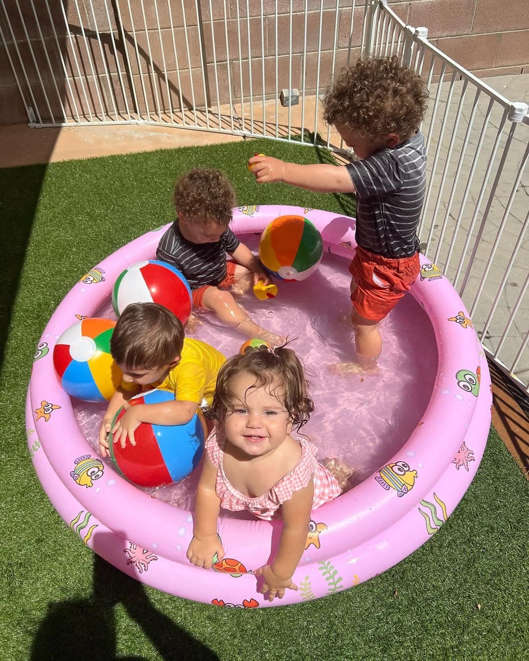 Children splashing and playing in a pool on a sunny day